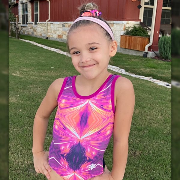 A gymnast in a pink gymnastics leotard