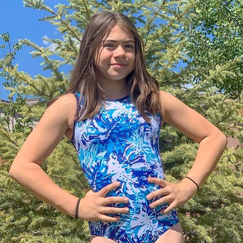 A gymnast in a blue and white gymnastic leotard.