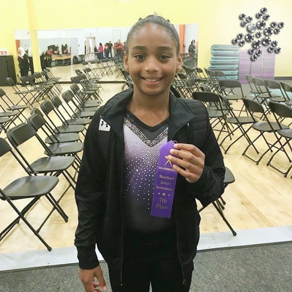 Gymnast at a competition with a ribbon.
