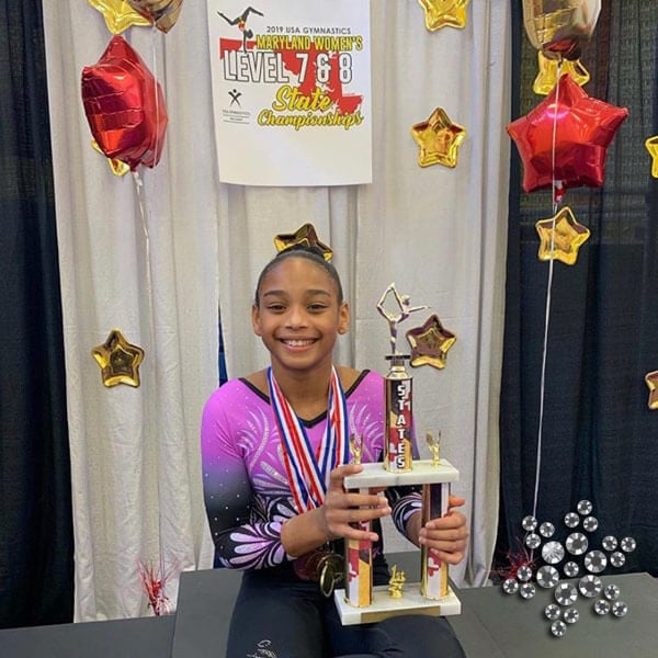 Gymnast at a competition with a trophy.