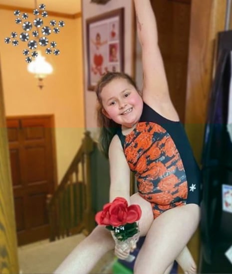 A gymnast in a red and black gymnastics leotard.