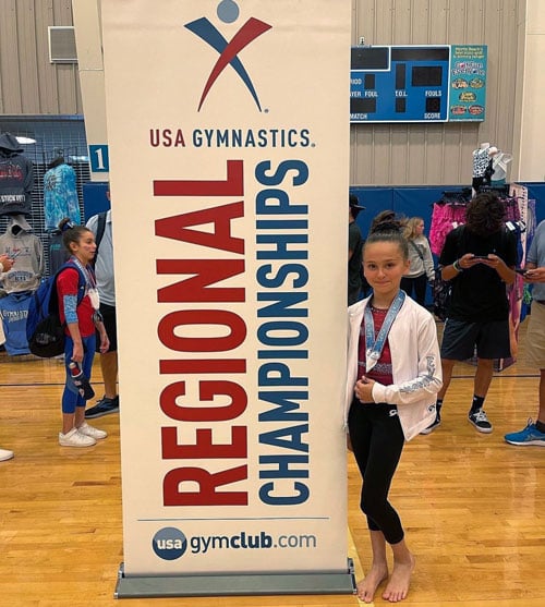 gymnast in white warm-up jacket