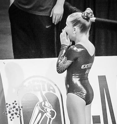 A gymnast in a snowflake competition leotard at a gymnastics meet